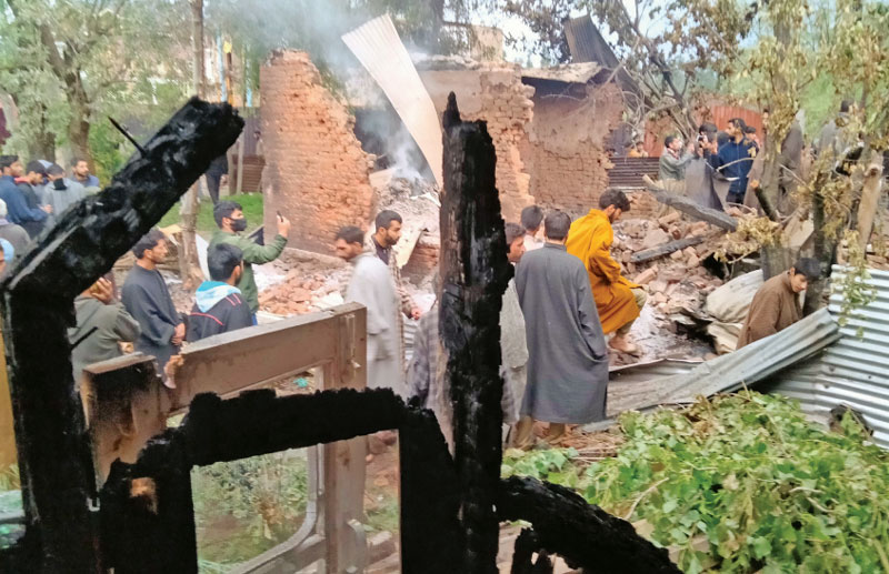 Villagers examine the ruins their homes in Baramulla